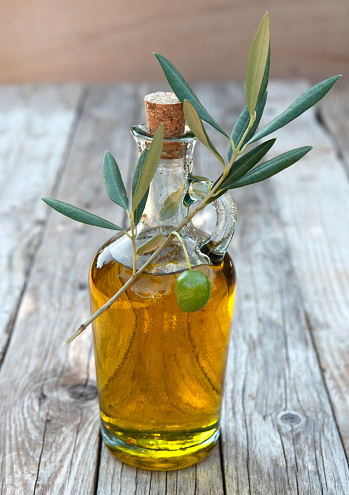 Olive oil in bottle and olive branch.