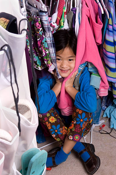 istock Girl surrounded by clothes in closet 182446451