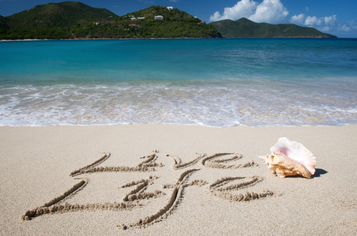 Live Life message handwritten in sand with a conch shell on tranquil tropical beach