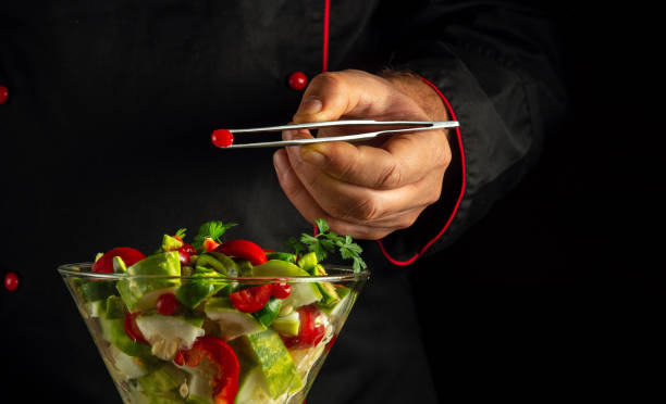 Chef preparing vegetarian food for breakfast in bowl. Delicious salad from fresh vegetables by the hands of a cook in the kitchen. Menu idea for a hotel or restaurant