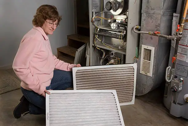 Photo of Woman DIY Homeowner Inspects Dirty and Clean Air Filters