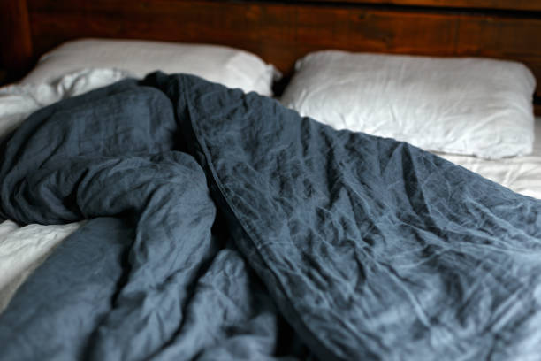 istock cosy Interior with white bed linen. Bedroom with oak bed, grey and blue bedding, and bedside table 1824482288