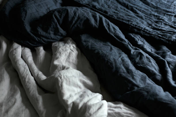 istock cosy Interior with white bed linen. Bedroom with oak bed, grey and blue bedding, and bedside table 1824482289
