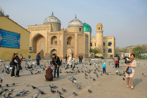 Khujand, Tajikistan - November 29, 2023: People walking next to the Mausoleum of Sheik Muslihiddin in Khujand, Tajikistan.