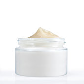 Jar of beige colored face cream upright with the lid off