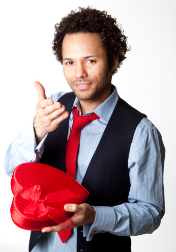 attractive man offering Valentine box to the camera on white background