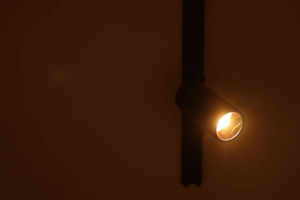 istock A Black Aluminum Track Light illuminated by a Track spot light on the white ceiling directing sideways in darkness 1824550614