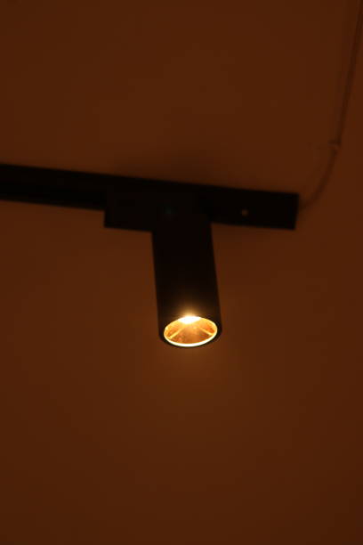 istock A Black Aluminum Track Light illuminated by a Track spot light on the white ceiling directing downward in darkness 1824551474