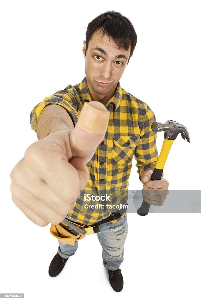 Carpenter with Bandaid on Thumb Handyman with bandaid on thumb and hammer looks pained Humor Stock Photo