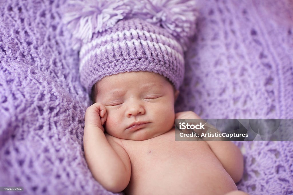 Menina de bebê recém-nascido dormindo em tricô, usando Chapéu roxo cobertor - Foto de stock de Bebê royalty-free