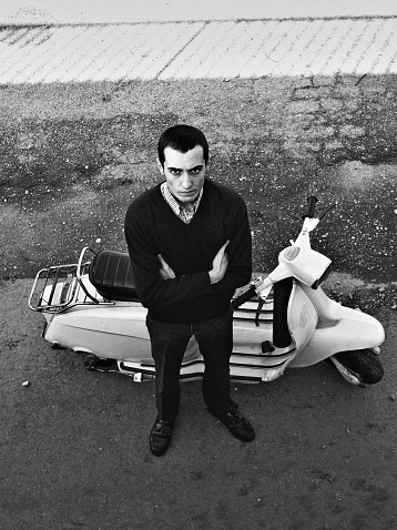 Young mod with old scooter. Black and white with high contrast. Grain.Young mod. Black and white with high contrast.