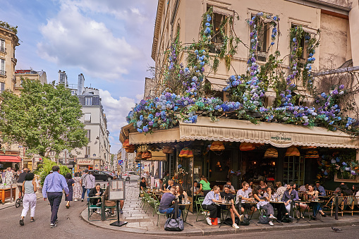 Paris, France - May 20, 2021: Day after lockdown due to covid-19 in a famous Parisian cafe with Eiffel tower in background in Paris