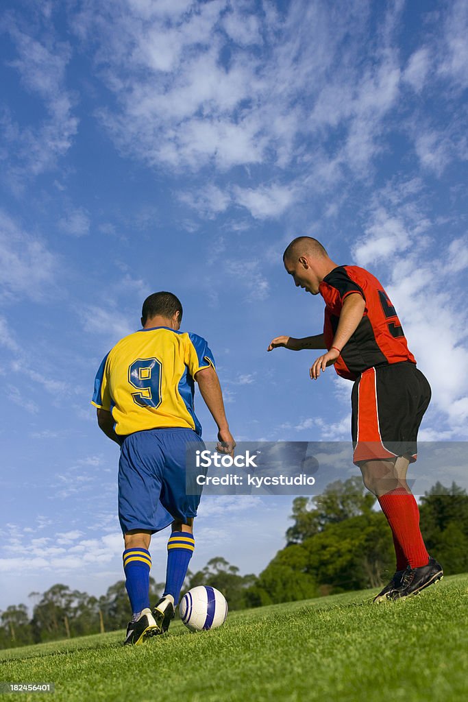 Two soccer players in action A soccer stricker tries to pass a defender with the ball. Activity Stock Photo