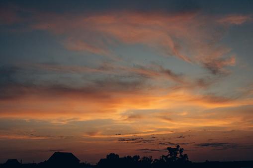 An image of a beautiful and unusual sunset. The ever-changing sky. An inspiring observation of clouds and the surrounding natural world. Can be used as banner background, wallpaper