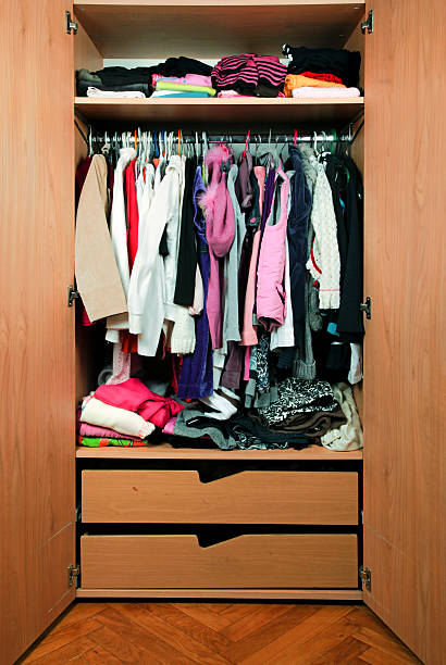 White t-shirts on hangers in wardrobe