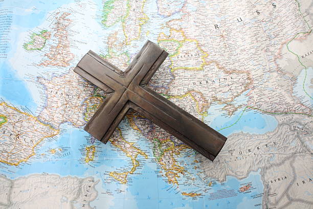 Map of Europe laying flat with a brown cross laid on top.