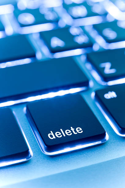 Computer laptop keypad 'delete' button. Shallow depth of focus, focus is through the 'delete' word on the keypad button.  delete key stock pictures, royalty-free photos & images