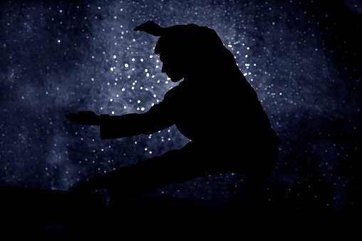 Tai chi man against starry sky at night with nebula and copy-space.