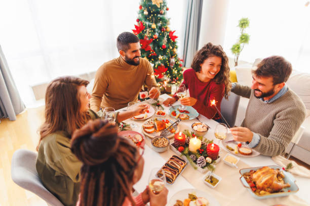 istock Friends celebrating Christmas together at home, waving with sparklers while having dinner 1824578961