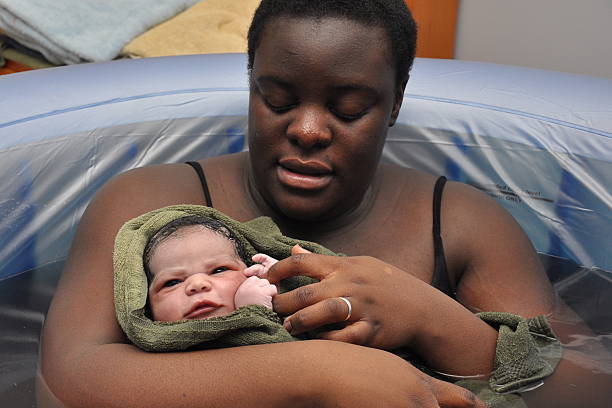 Baby Day~ Water Birth; newborn opens eyes stock photo