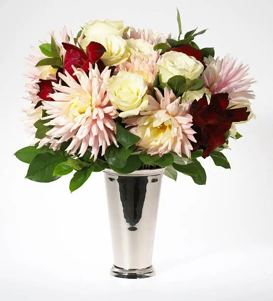 Silver reflective vase with a  bouquet of fresh cut flowers photgraphed on a white background