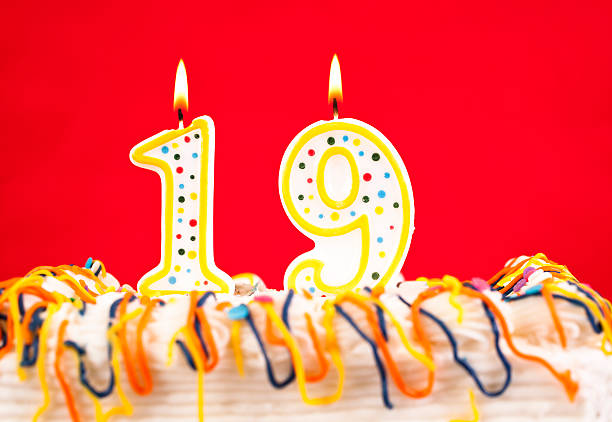 istock Decorated cake  with number 19 burning candles 182459349