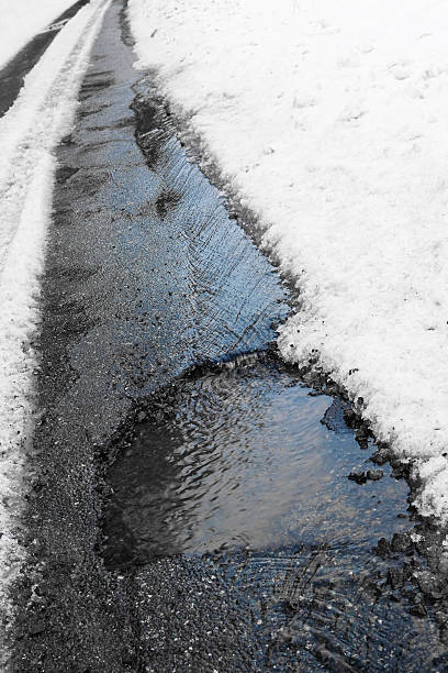 istock Pothole in road in winter 182459370