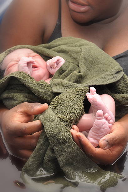 Baby-Day; water birth; ten fingers and toes mother holding newly born daughter, her tiny feet in mommy's hand water birth stock pictures, royalty-free photos & images