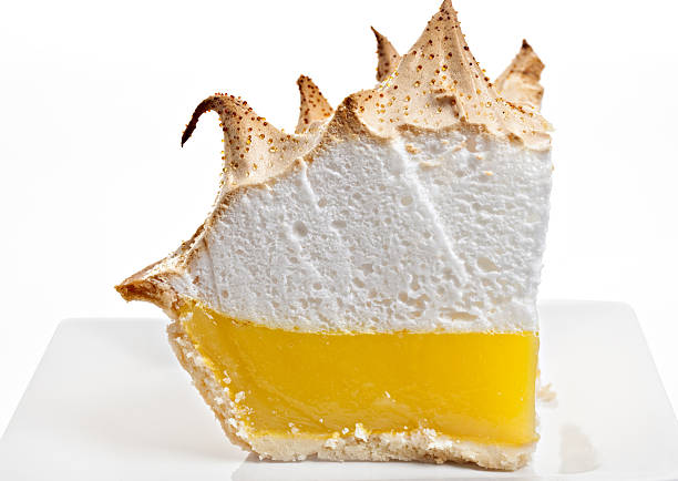 Lemon Meringue Pie Slice A slice of lemon meringue pie on a white background. meringue stock pictures, royalty-free photos & images