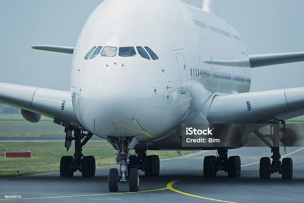 Grande estreito o taxiamento na pista, vista frontal - Foto de stock de Avião Movendo-se na Pista royalty-free