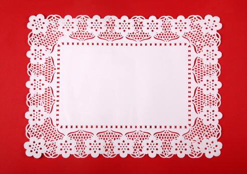 Paper doily on red cardboard.See also