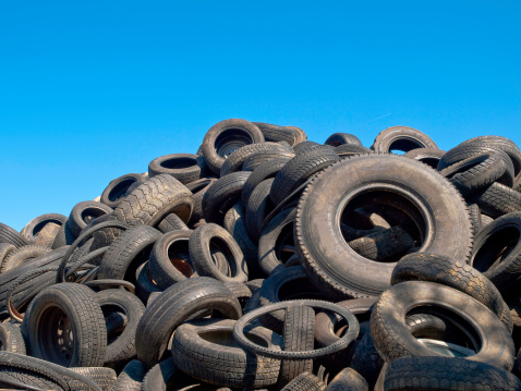 Old tyres waiting to be recycled in a scrapyard.