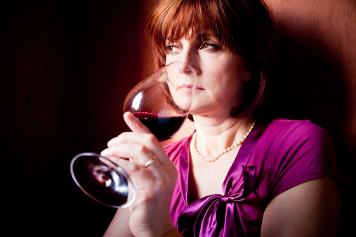 Adult woman tasting wine.