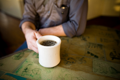 Man sitting in coffee shop with a fresh mug of black coffee.