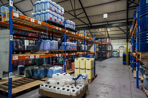 A wide shot of an ink factory filled with containers and barrels of ink.