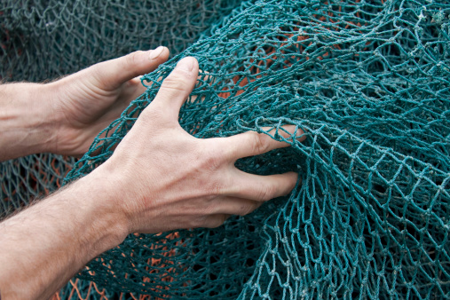 A fisherman holding up the fishing nets