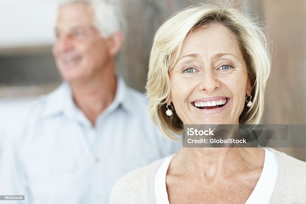 Szczęśliwy dojrzała kobieta z mężem w tle - Zbiór zdjęć royalty-free (Nieostry)