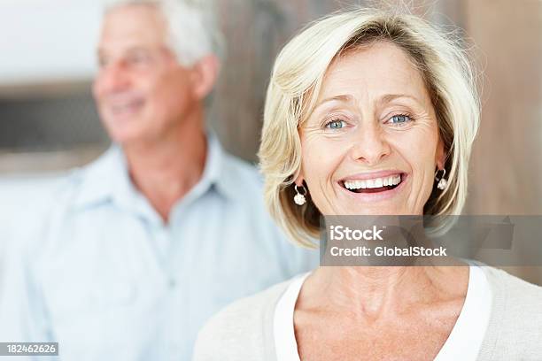 Szczęśliwy Dojrzała Kobieta Z Mężem W Tle - zdjęcia stockowe i więcej obrazów Nieostry - Nieostry, Starsi mężczyźni, Portret