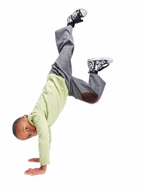 Photo of Young boy doing a handstand against white