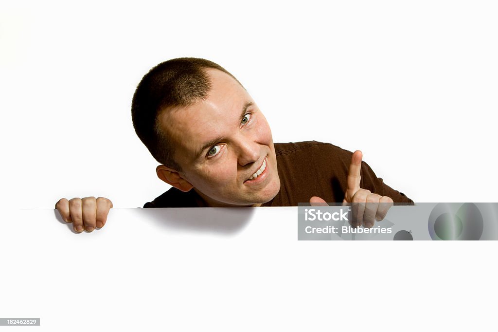 Notice Man behind a white frame with raised finger, looking at the camera. Adult Stock Photo