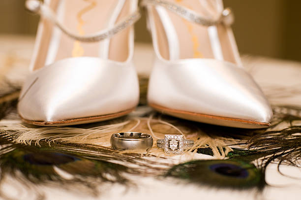 Bridal shoes and wedding rings A wedding bouquet of peacock feathers topped with elegant wedding shoes and amazing wedding rings wedding shoes stock pictures, royalty-free photos & images