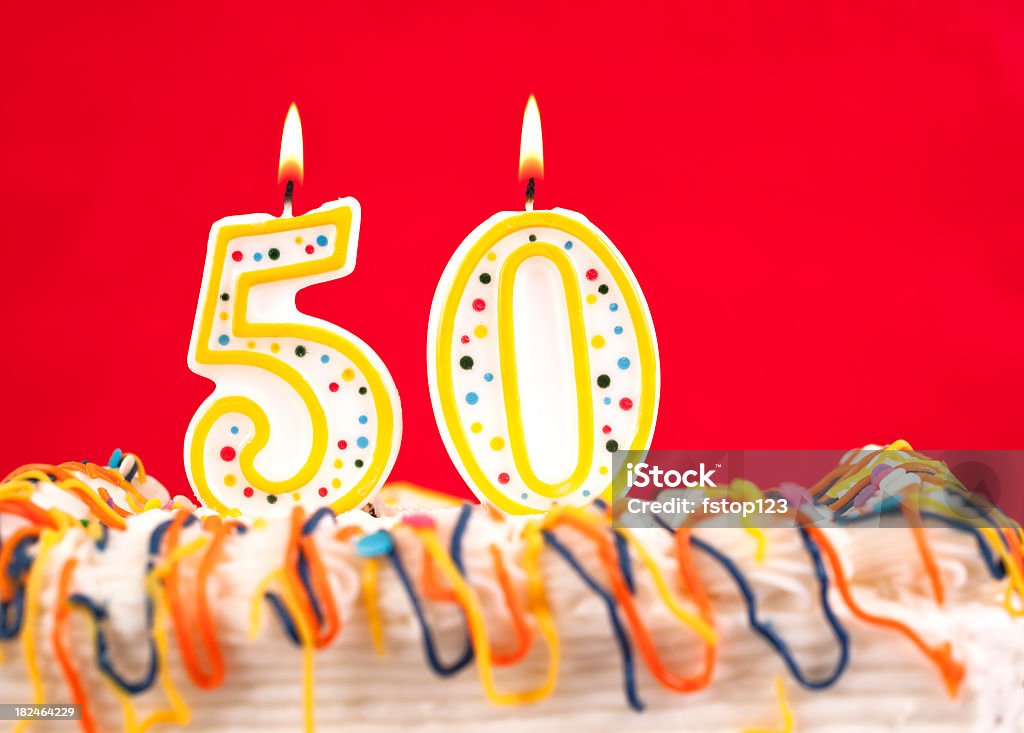 Das Geburtstagstorte mit brennenden Kerzen Nummer 50. Roter Hintergrund. - Lizenzfrei Zahl 50 Stock-Foto