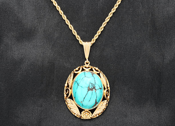 istock Turquoise Pendant in Gold Setting on Black Textile 182464432