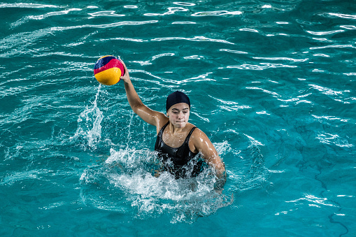 Young woman playing water polo