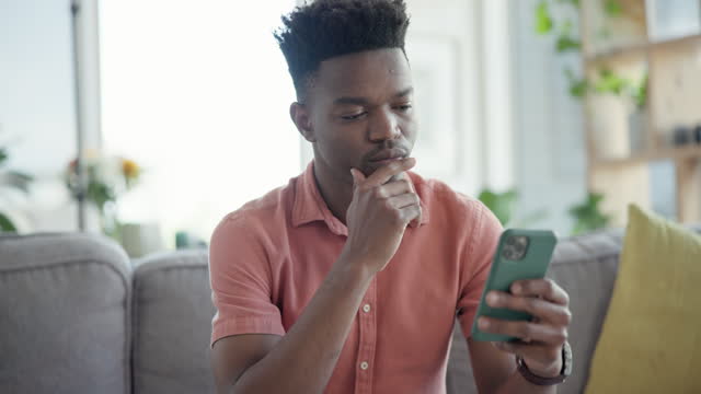 Black man, smartphone and reading online with social media, relax on sofa at home with technology and internet. Connection, text message or email with contact, chat and search website or blog