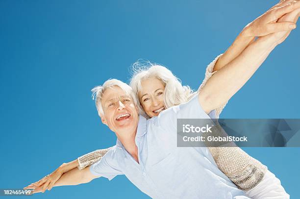 Coppia Senior Stretching Loro Mani Insieme Contro Il Cielo Blu - Fotografie stock e altre immagini di 55-59 anni