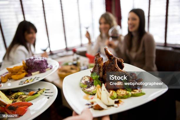 Foto de Almoço Pratos Com Businesswomen Ao Fundo e mais fotos de stock de Restaurante - Restaurante, Desfocado - Foco, Adulto