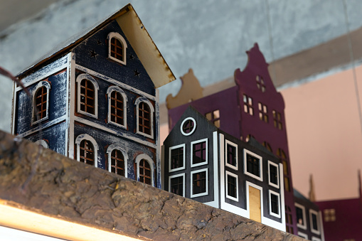 Decorative colorful wooden toy houses stand in a row on a shelf in a gift shop