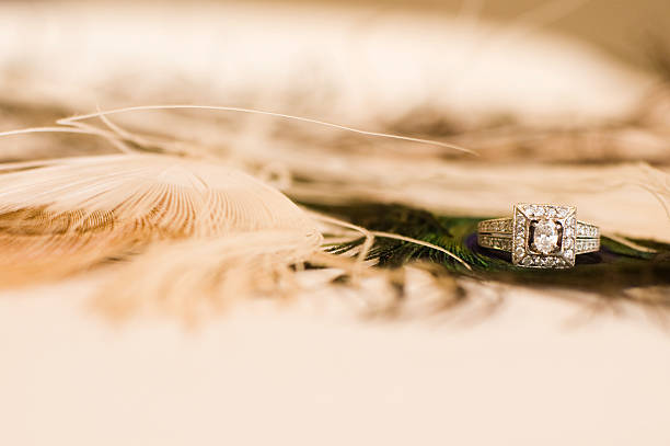 Antique wedding ring on peacock feathers stock photo