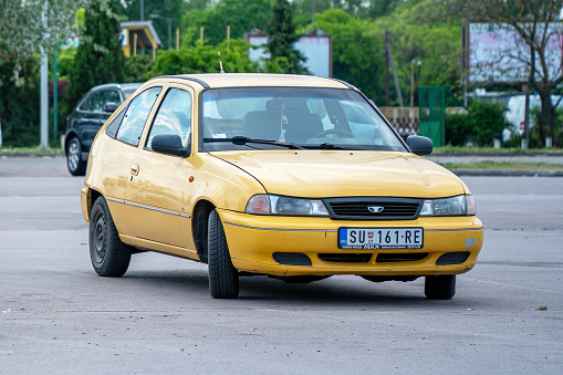 Licensed copy of Opel Kadett E - Daewoo Nexia (Cielo, Racer) with rare body 3-door hatchback in yellow color is parked in Subotica, Serbia, 05.05.2023
